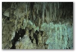 Salle des Concrétions et Lac Noir. Le jeu d’ombre et de lumière met en valeur la beauté naturelle de la grotte.